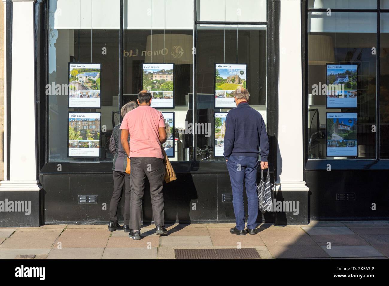 Gente mirando en la ventana de una oficina de agentes inmobiliarios en Bath, Somerset, Inglaterra, Reino Unido Foto de stock