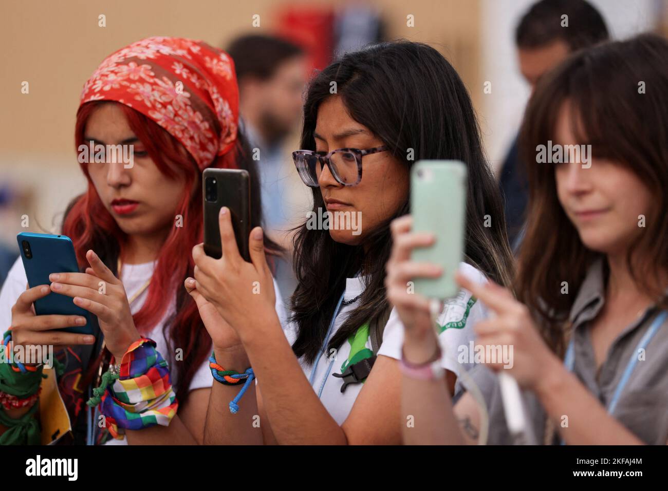 La gente usa sus teléfonos mientras los activistas climáticos toman parte en una protesta durante la cumbre climática del COP27, en Sharm el-Sheikh, Egipto, el 17 de noviembre de 2022. REUTERS/Mohamed Abd El Ghany Foto de stock