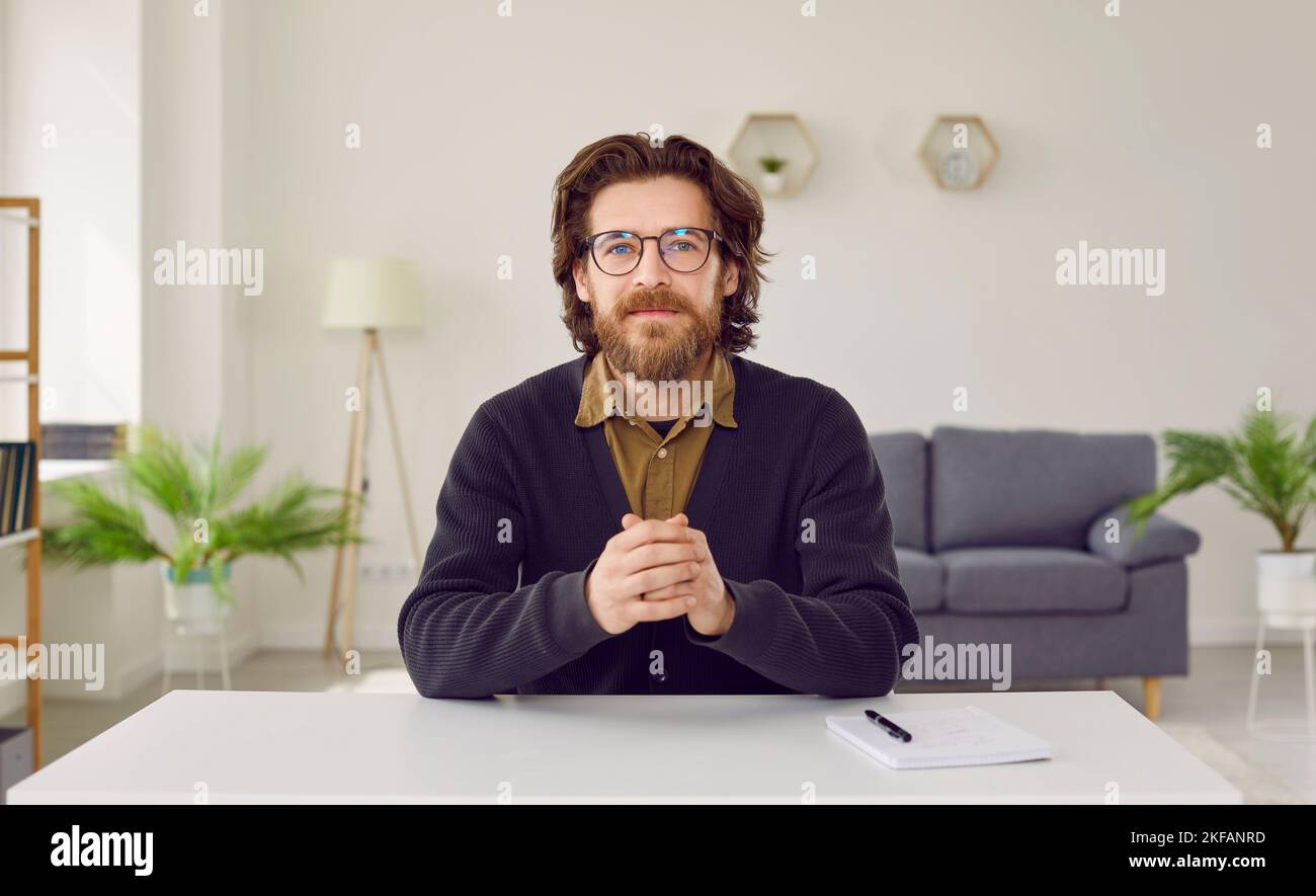 Retrato de un empresario o profesor sentado en el escritorio durante la videoconferencia Foto de stock