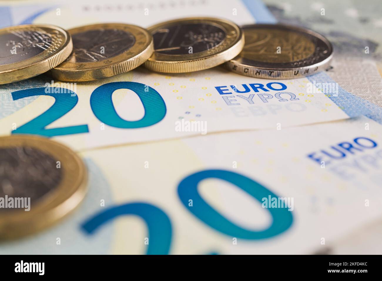 Una y dos monedas de euro sobre los billetes de banco en papel con denominación de veinte euros. Foto de stock