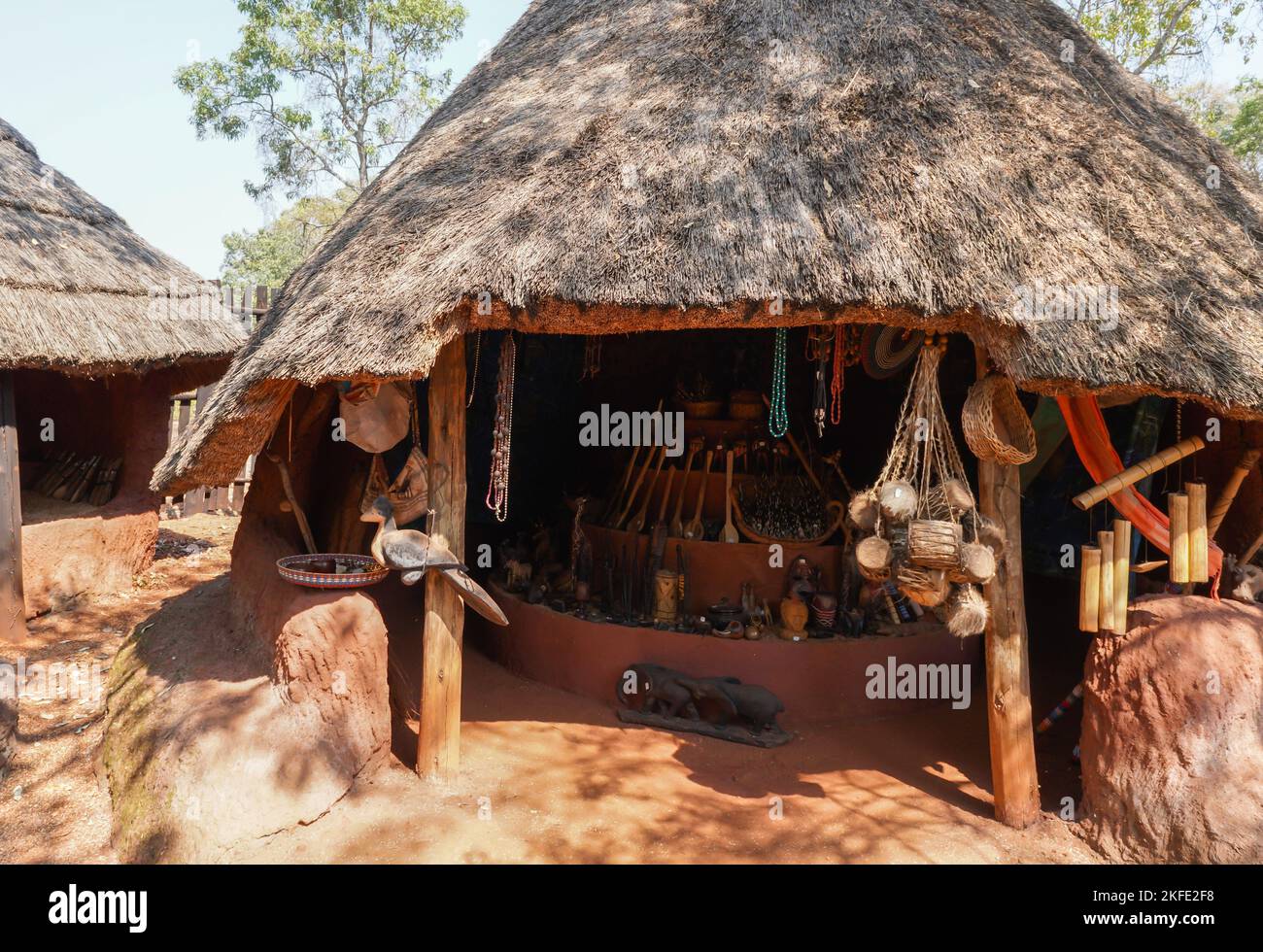 Aldea cultural shangaan Cabaña tradicional africana de paja con recuerdos o recuerdos colgando afuera en exhibición para que los turistas compren en Sudáfrica Foto de stock