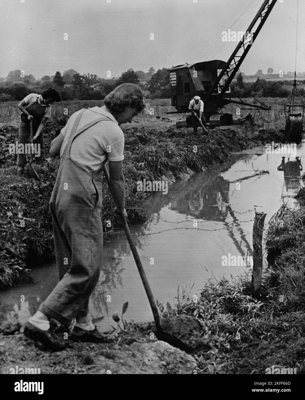 Foto de la época Hacia el 1943 de abril de mujeres británicas no identificadas trabajando en una granja cavando zanjas de drenaje con palas en Devon rural como parte del Ejército de Tierra de Mujeres ayudando a producir alimentos durante la Segunda Guerra Mundial Foto de stock