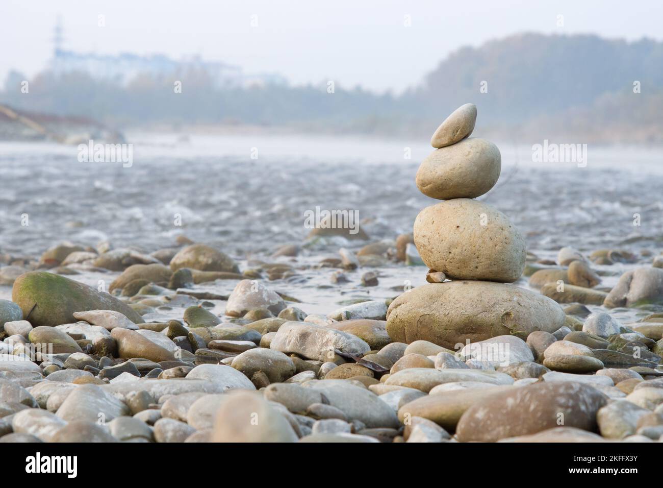 Saldos de piedras en la playa de mar azul con la montaña Foto de stock