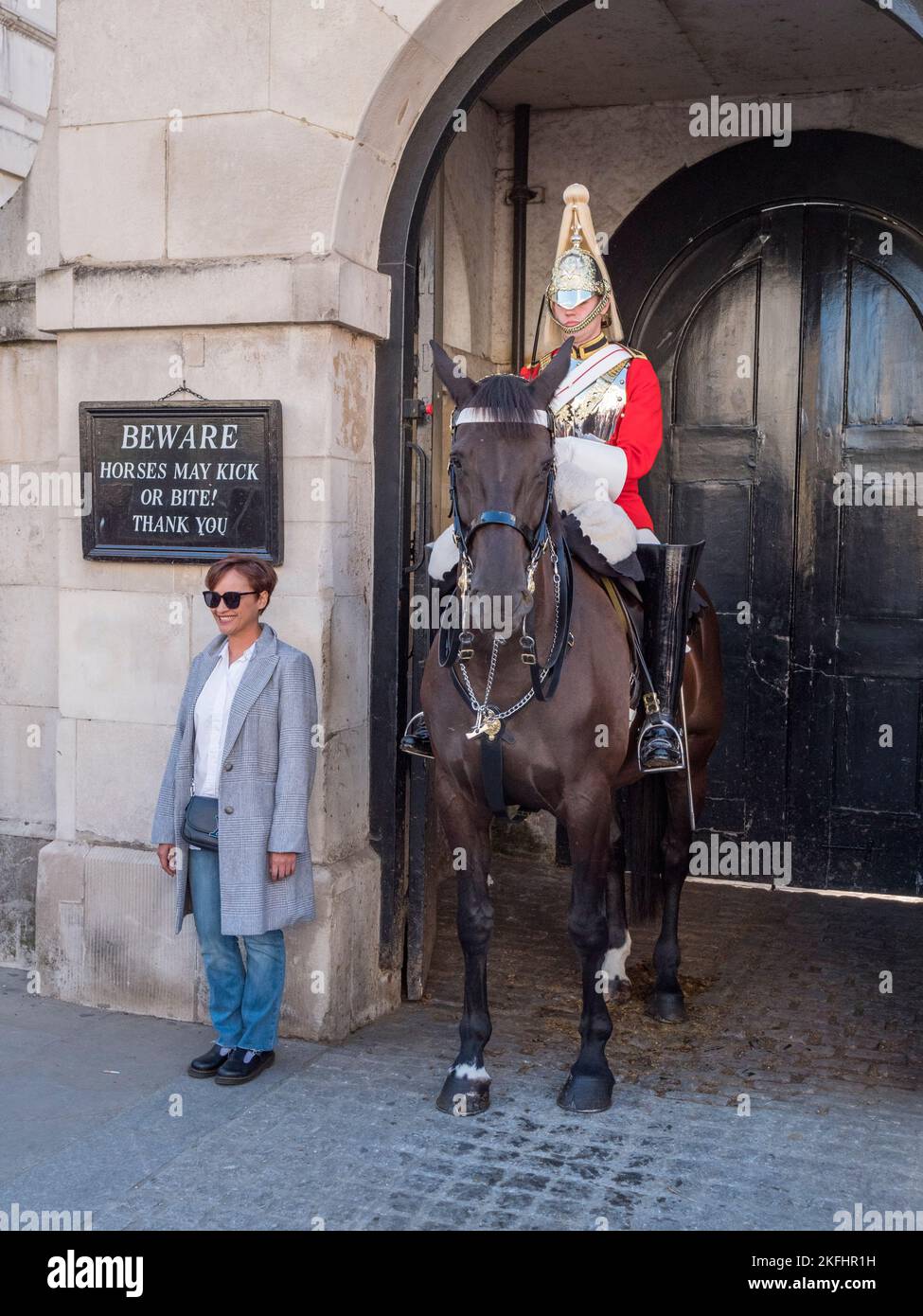 Un turista posando con un Life Guard montado de servicio en el cuartel de los Horse Guards en Whitehall, Londres, Reino Unido. Foto de stock