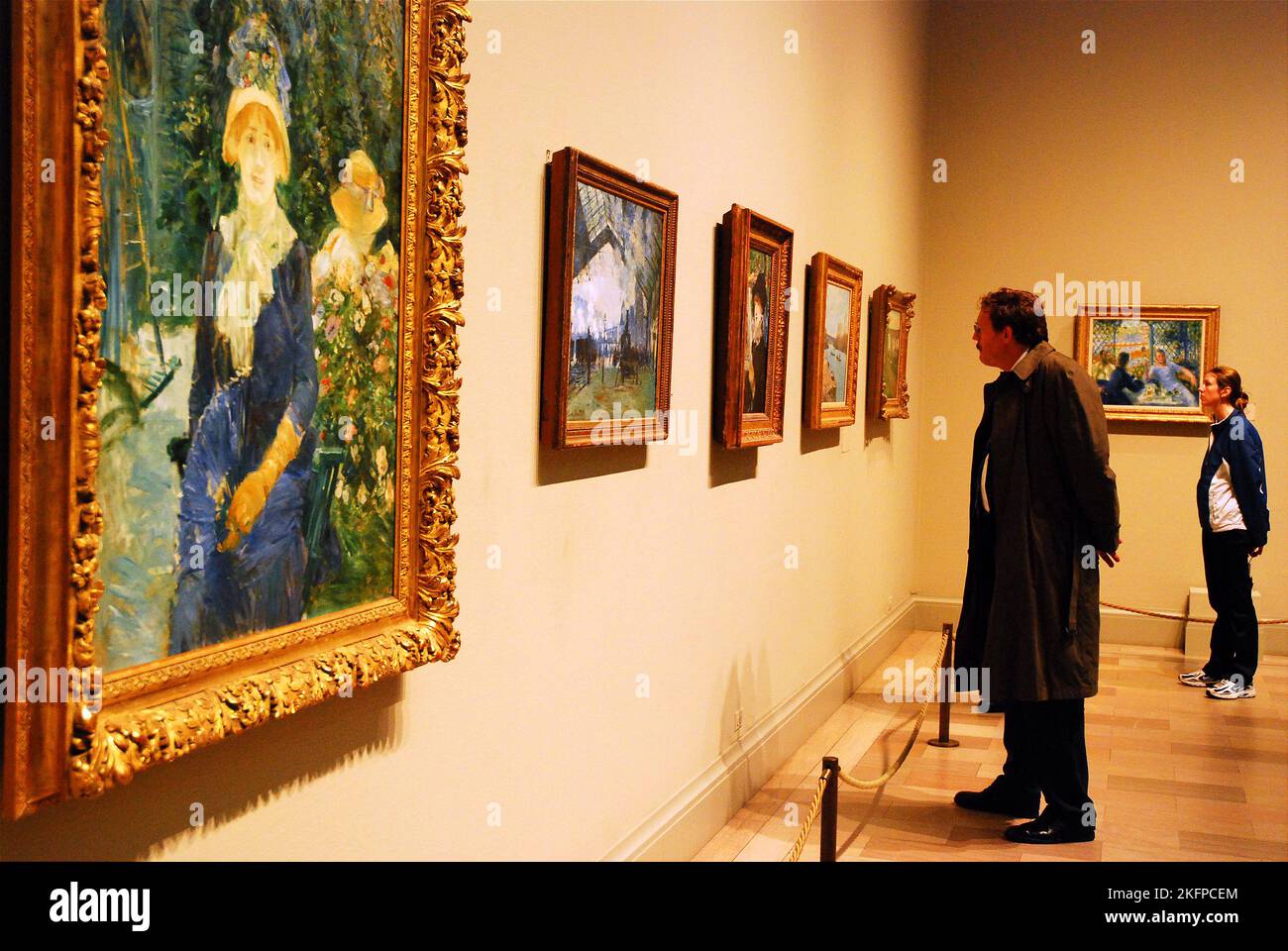Un hombre y una mujer adultos se maravillan ante las pinturas de los maestros europeos en una galería-museo del Instituto de Arte de Chicago Foto de stock