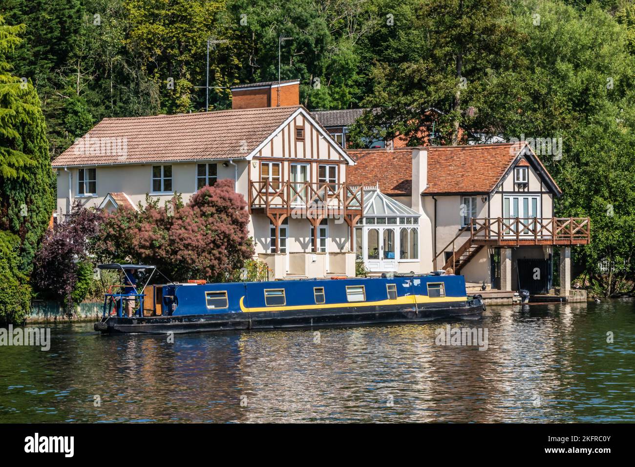 Casa y barcaza en el río Támesis ai Henley on Thames, Oxfordshire, Inglaterra Foto de stock