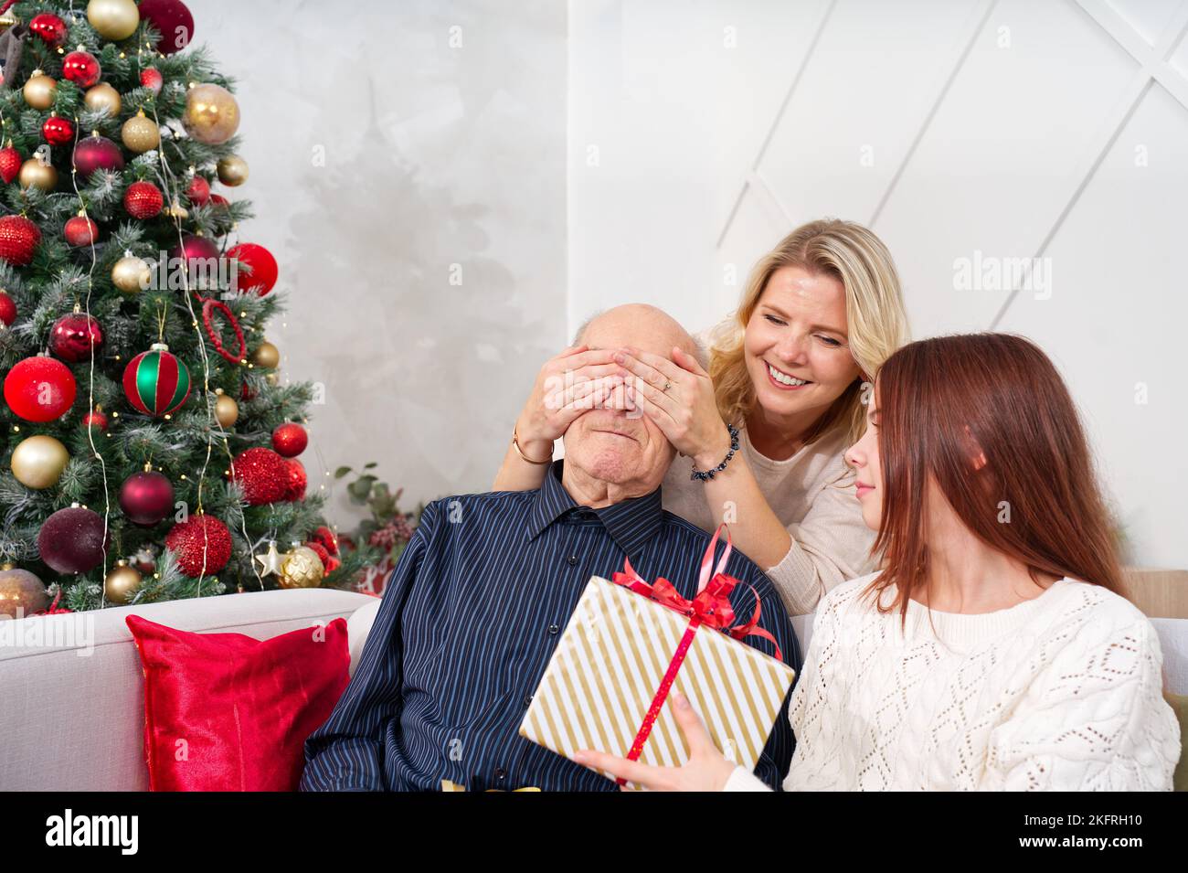 El abuelo dando una caja de regalo a una nieta feliz