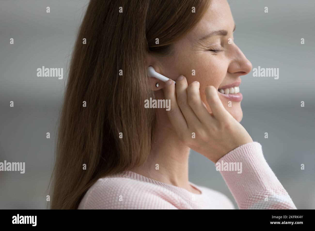 Primer plano cara de mujer Disfrute de la música a través de auriculares inalámbricos Foto de stock