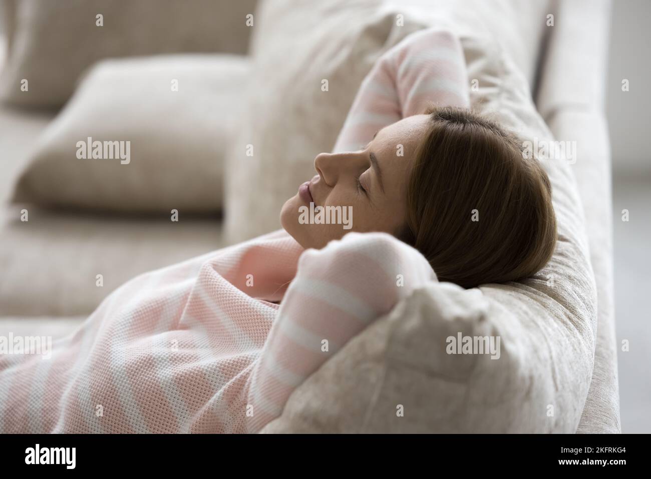 Una mujer tranquila descansando se apoyó en cómodos sofás cojines, vista superior Foto de stock