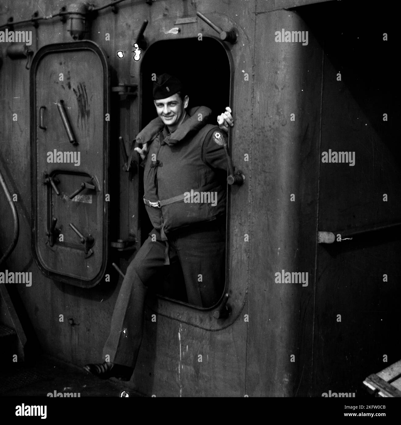 Hombre sonriendo a la cámara. Veteranos del Ejército de los Estados Unidos que regresan a casa en el buque Elgin Victory al final de la Segunda Guerra Mundial SS Elgin Victory, un buque tipo VC2-S-AP2 Victory construido por Permanente Metals Foto de stock