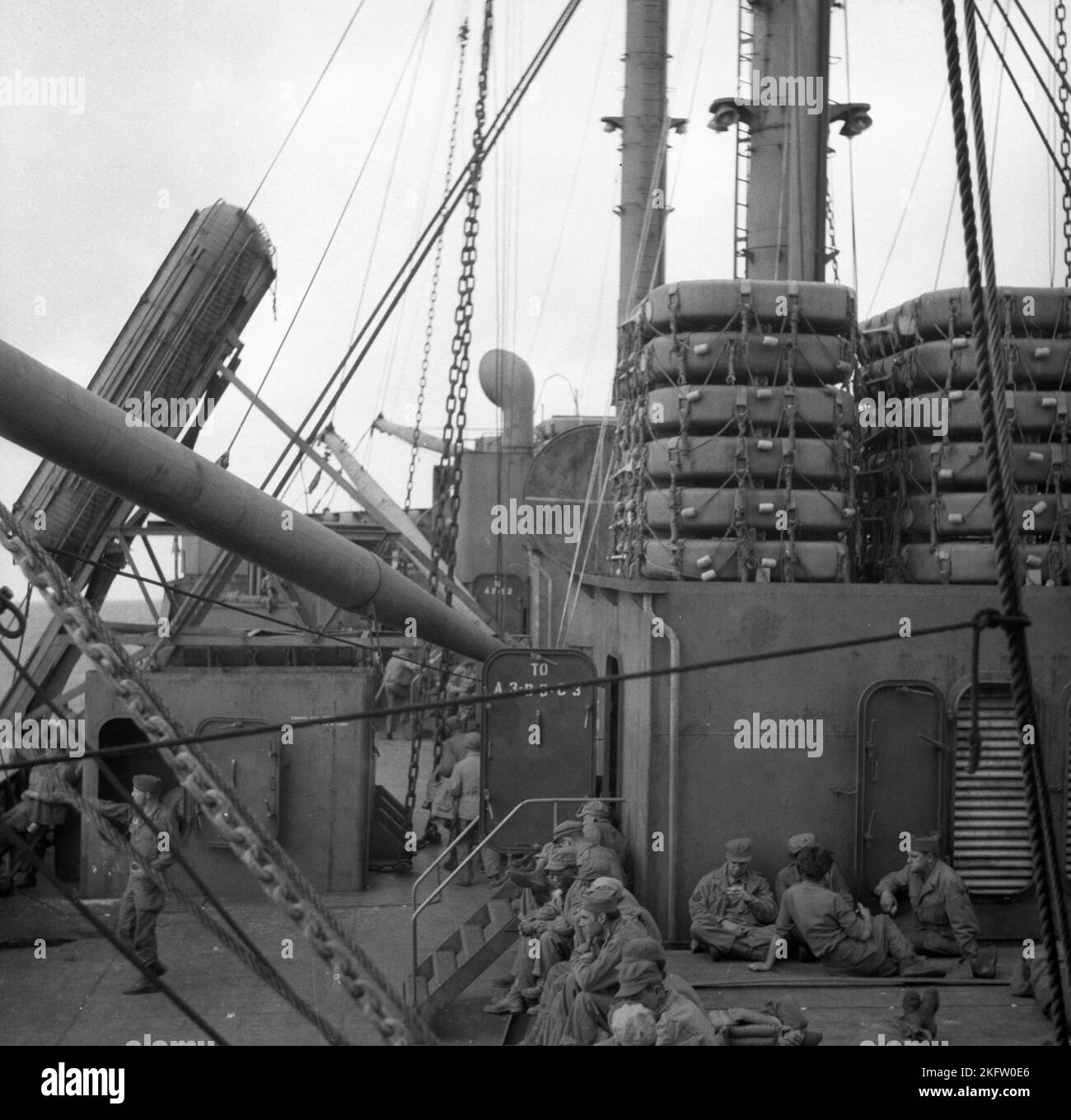 Hombres sentados en la cubierta del barco. Veteranos del Ejército de los Estados Unidos que regresan a casa en el buque Elgin Victory al final de la Segunda Guerra Mundial SS Elgin Victory, un buque tipo VC2-S-AP2 Victory construido por Permanente Metals Foto de stock