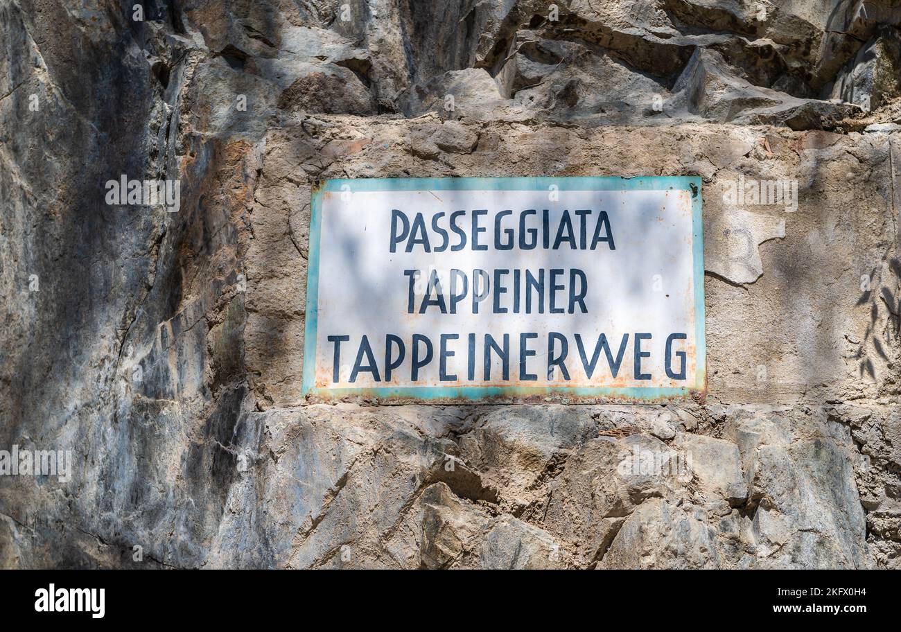 Cartel bilingüe de Tappeinerweg en alemán e italiano, Passeggiata Tappeiner, en una pared de piedra. Merano. Provincia Bolzano, Tirol del Sur, norte de Italia Foto de stock