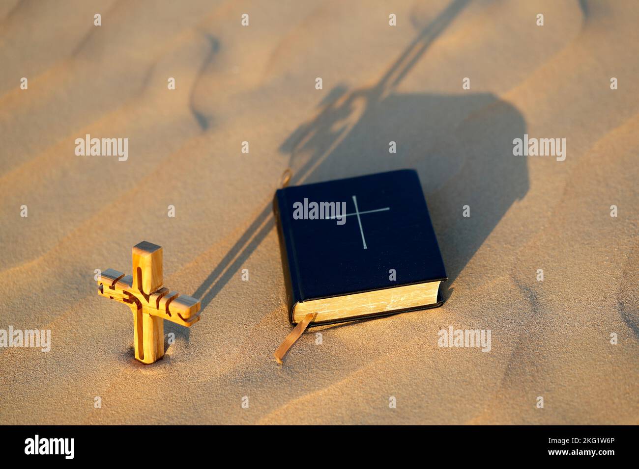 una biblia y una sombra de una cruz cristiana de madera con el nombre