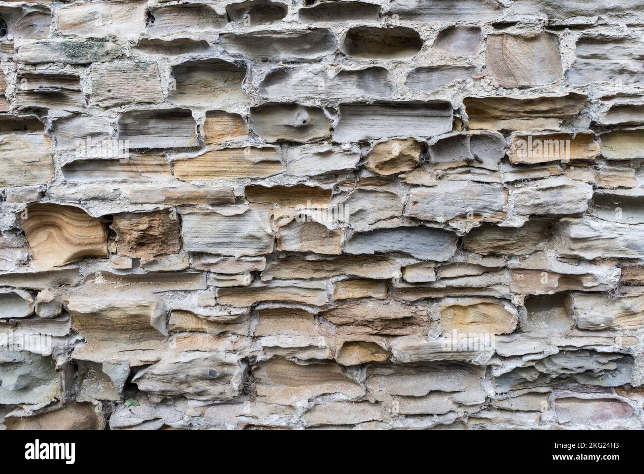 Un viejo muro de piedra que ha sido muy erosionado Foto de stock