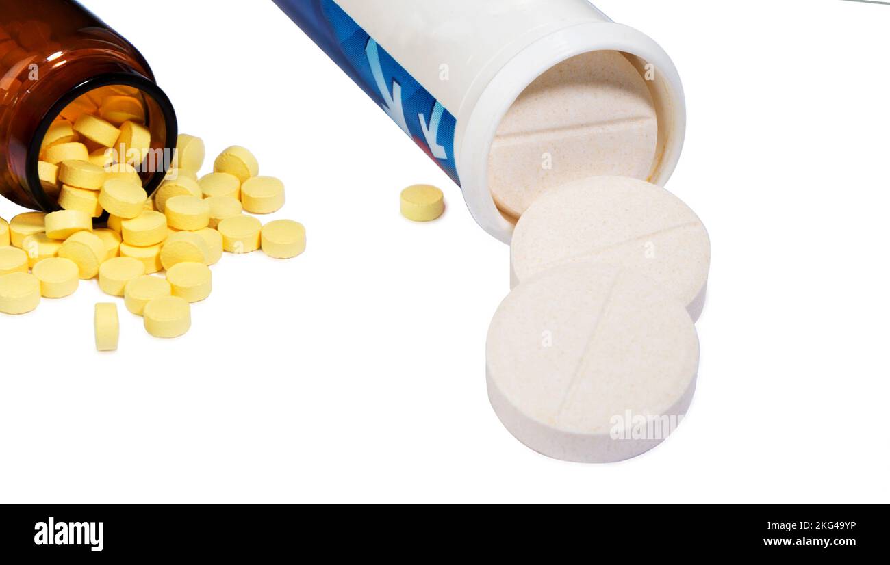 Las píldoras se derraman de una botella de droga de la píldora, aisladas sobre fondo blanco. Foto de stock