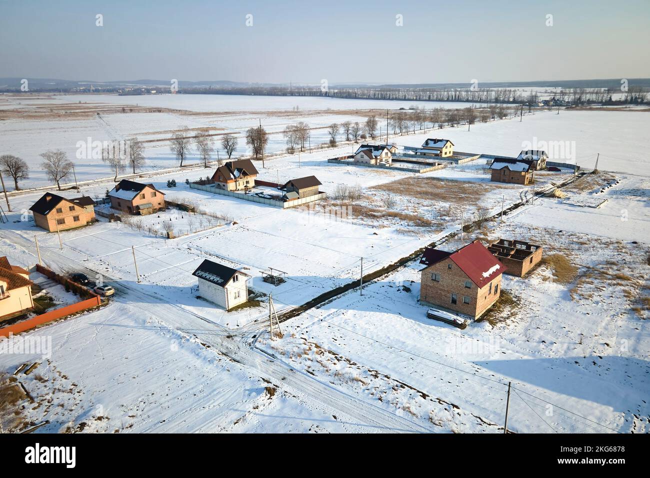 Vista aérea de casas privadas con techos cubiertos de nieve en la zona de la ciudad de los suburbios rurales en invierno frío Foto de stock