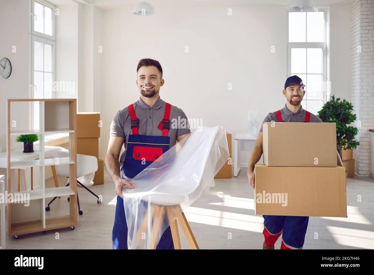 Dos hombres del servicio de reparto sacando muebles y cajas de cartón de la casa Foto de stock