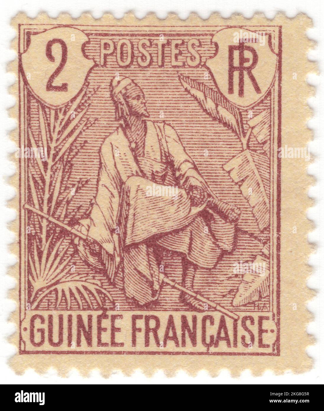 GUINEA FRANCESA - 1904: Un sello de franqueo de color marrón-violeta de 2 centésimas que representa a Fulah Shepherd. El pueblo fula, fulani o fulah es uno de los grupos étnicos más grandes del Sahel y África Occidental, ampliamente disperso por toda la región. Habitan en muchos países y viven principalmente en África occidental y en las partes septentrionales de África central, Sudán del Sur, Darfur y regiones cercanas a la costa del Mar Rojo en Sudán. Se desconoce el número aproximado de personas fula debido a las definiciones enfrentadas con respecto a la etnia fula. Varias estimaciones sitúan la cifra entre 25 y 40 millones de personas en todo el mundo Foto de stock