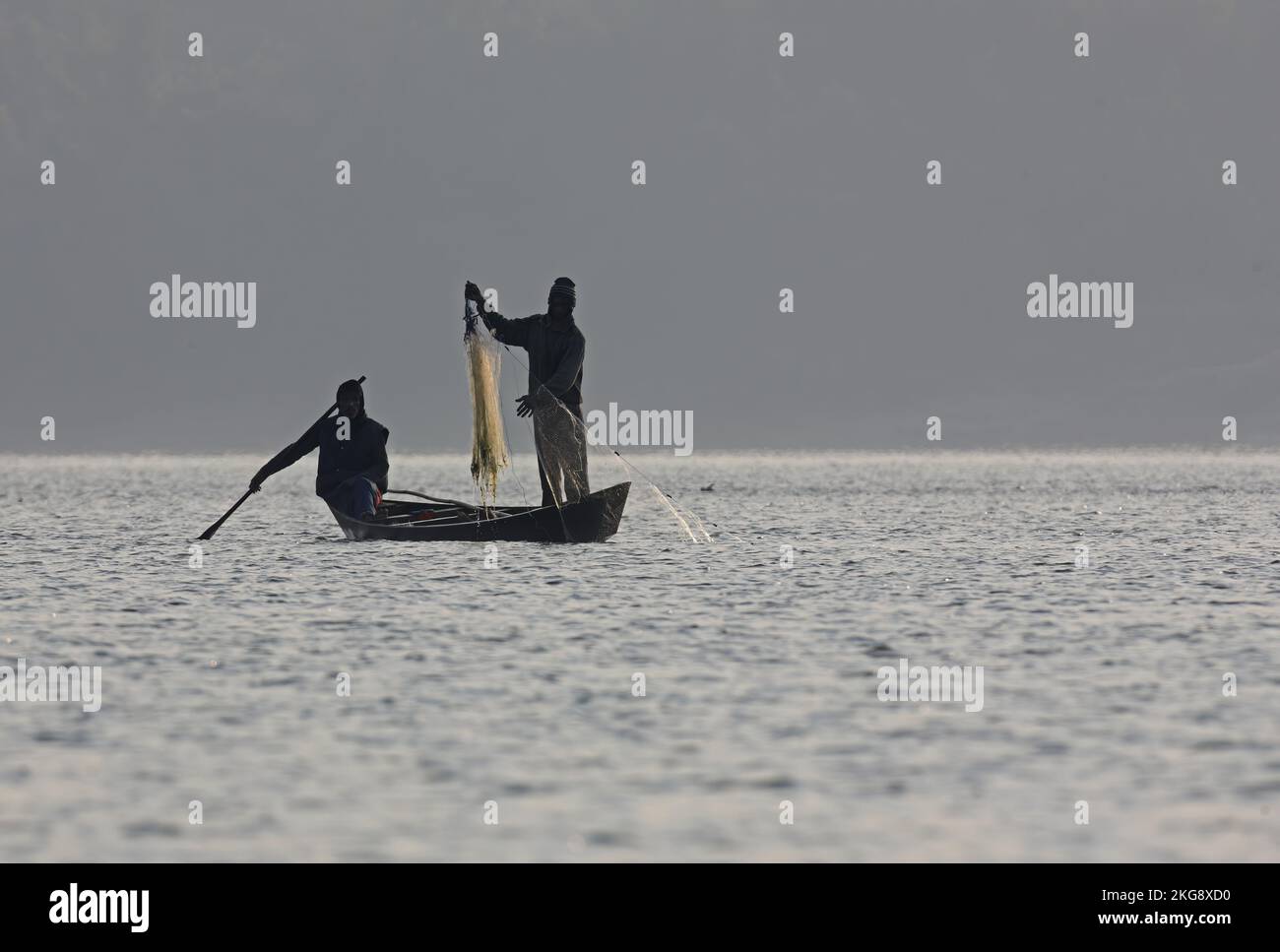 Dos hombres pescando en barco a primera hora de la mañana, Dibru-Saikhowa, Assam, India Febrero 2012 Foto de stock