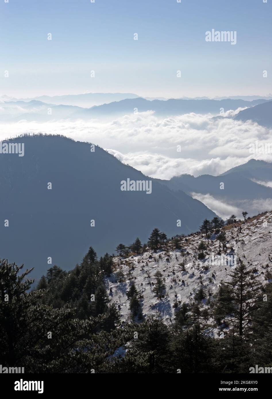 Vista sobre laderas nevadas por la mañana con nubes en el valle Eaglenest Wildlife Sanctuary, Arunachal Pradesh, India Enero Foto de stock