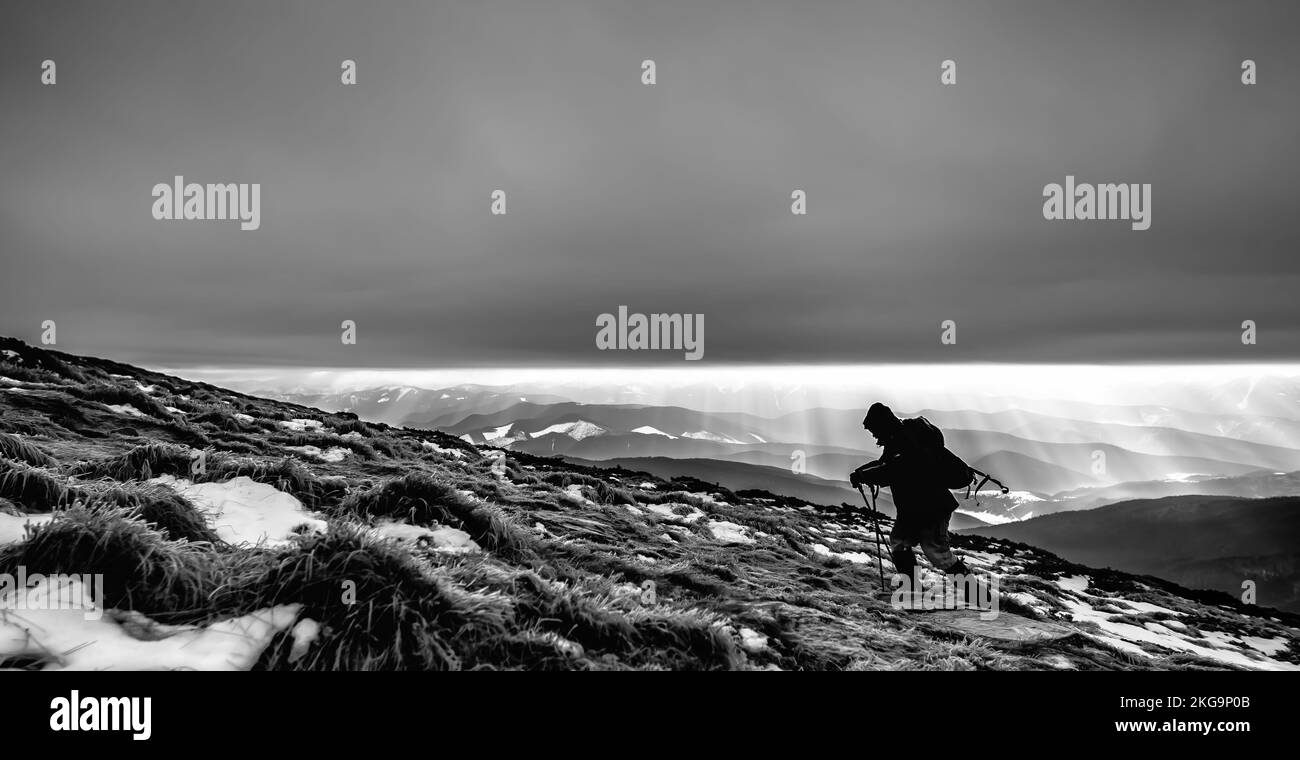 Climber lucha con el mal tiempo en las montañas de invierno Foto de stock