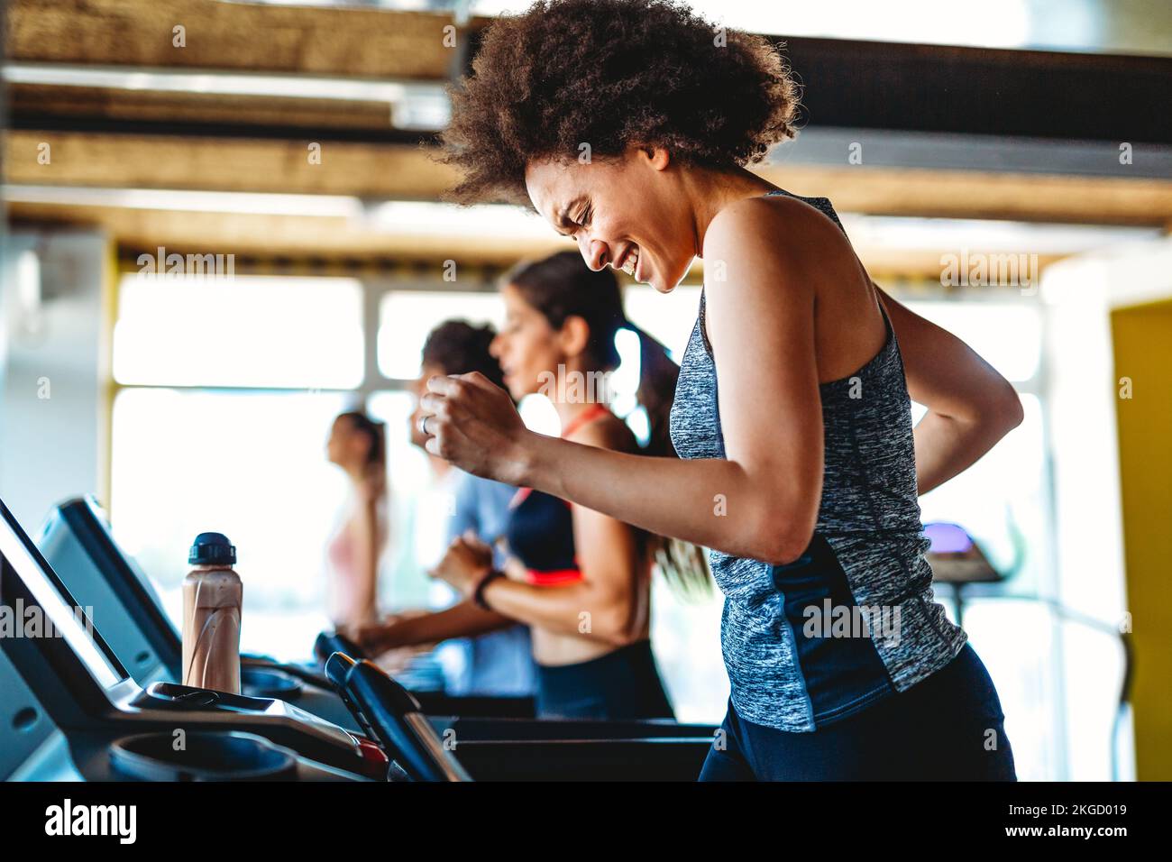 Grupo de personas en forma feliz en el gimnasio haciendo ejercicio, corriendo. Concepto de mantenerse saludable. Foto de stock