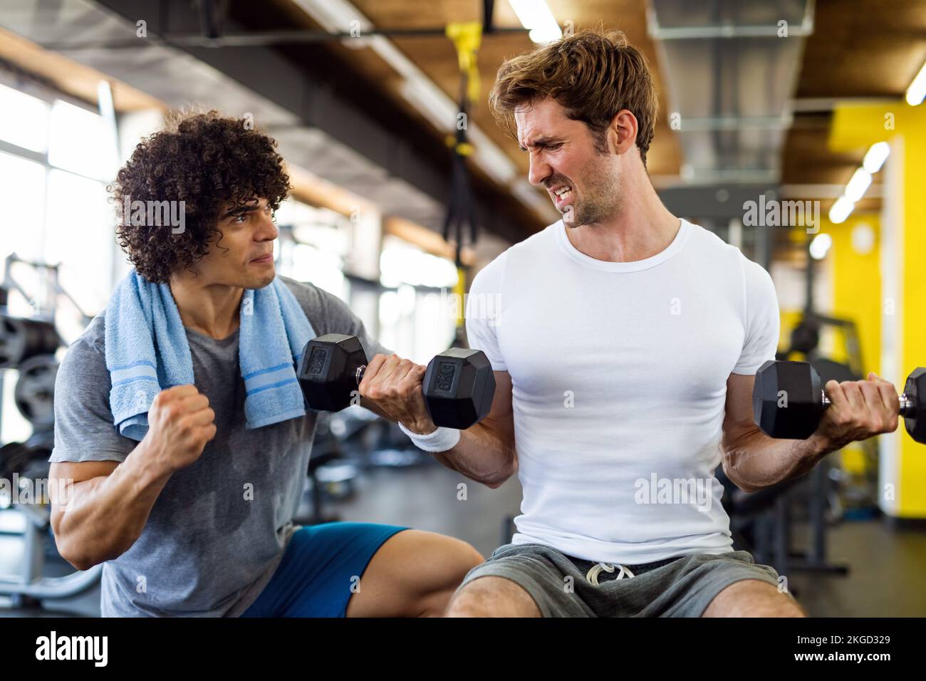 Hombre en forma haciendo ejercicio en el gimnasio con entrenador personal para mantenerse saludable. Deporte, concepto de personas Foto de stock