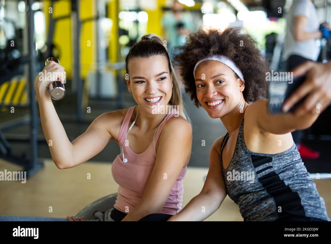 Mujeres en forma feliz, amigos sonriendo, hablando y tomando fotos después de hacer ejercicio en el gimnasio. Redes sociales. Foto de stock