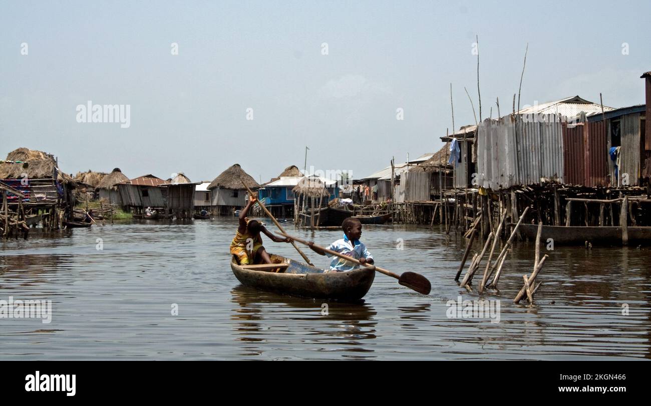 Casas sobre pilotes, Lake Village, Ganvie, Benín; Lago Nokoué, vida acuática; vida en el agua; niños en canoa. Esta ciudad no tiene calles excepto en la Foto de stock