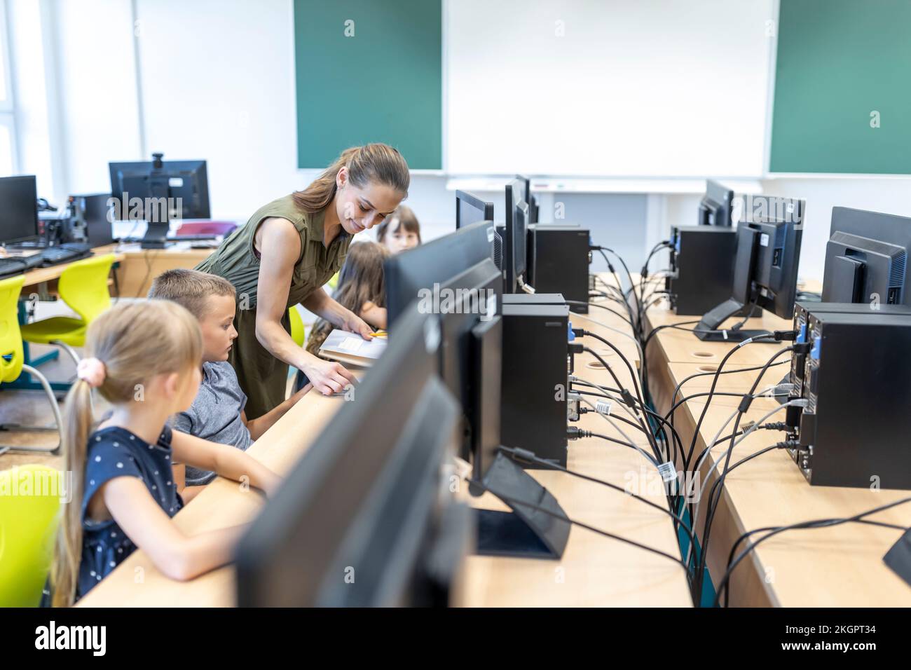 Maestro que enseña a los estudiantes a través de E-learning en clase en la escuela Foto de stock