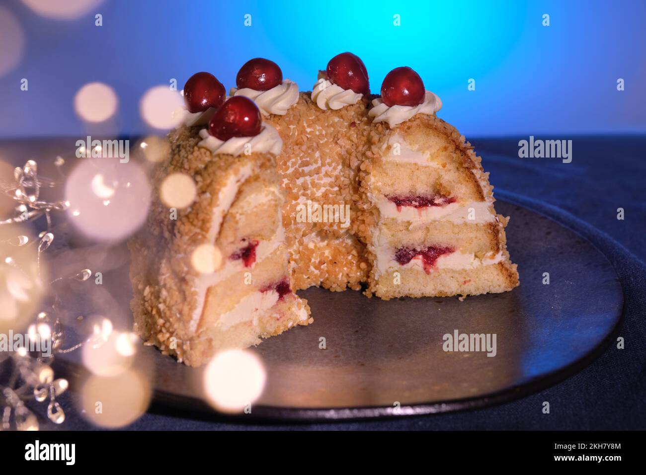 Pastel alemán Frankfurter Kranz o Frankfurt Crown Cake. Bisquit con crema de mantequilla y cerezas. Corte la mitad de la torta. Guirnalda de Navidad de invierno con Foto de stock
