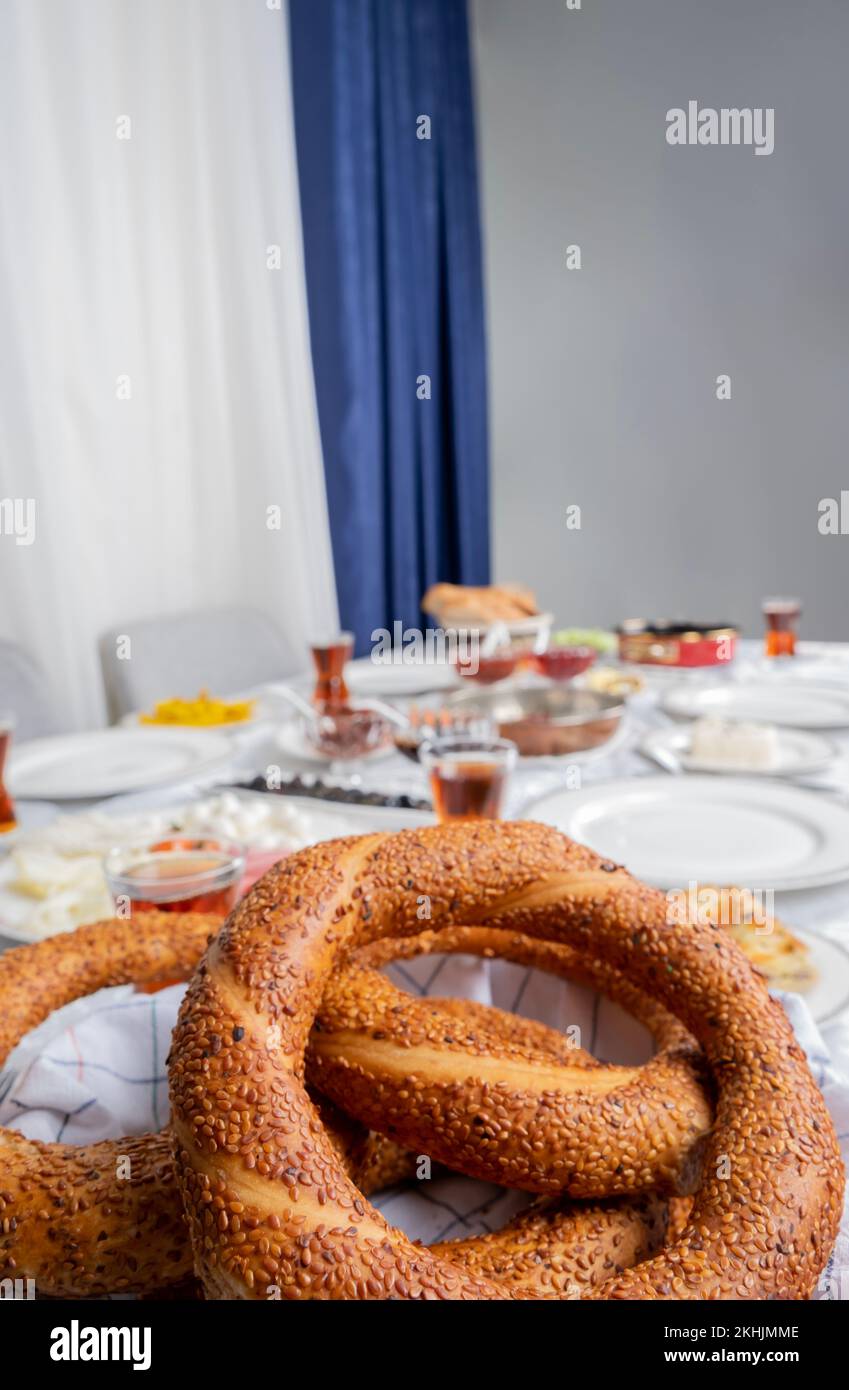 Bagel turco llamado simit, vista de cerca, enfoque selectivo en el bagel turco llamado simit. Fondo borroso de la configuración de la mesa de desayuno. Foto de stock