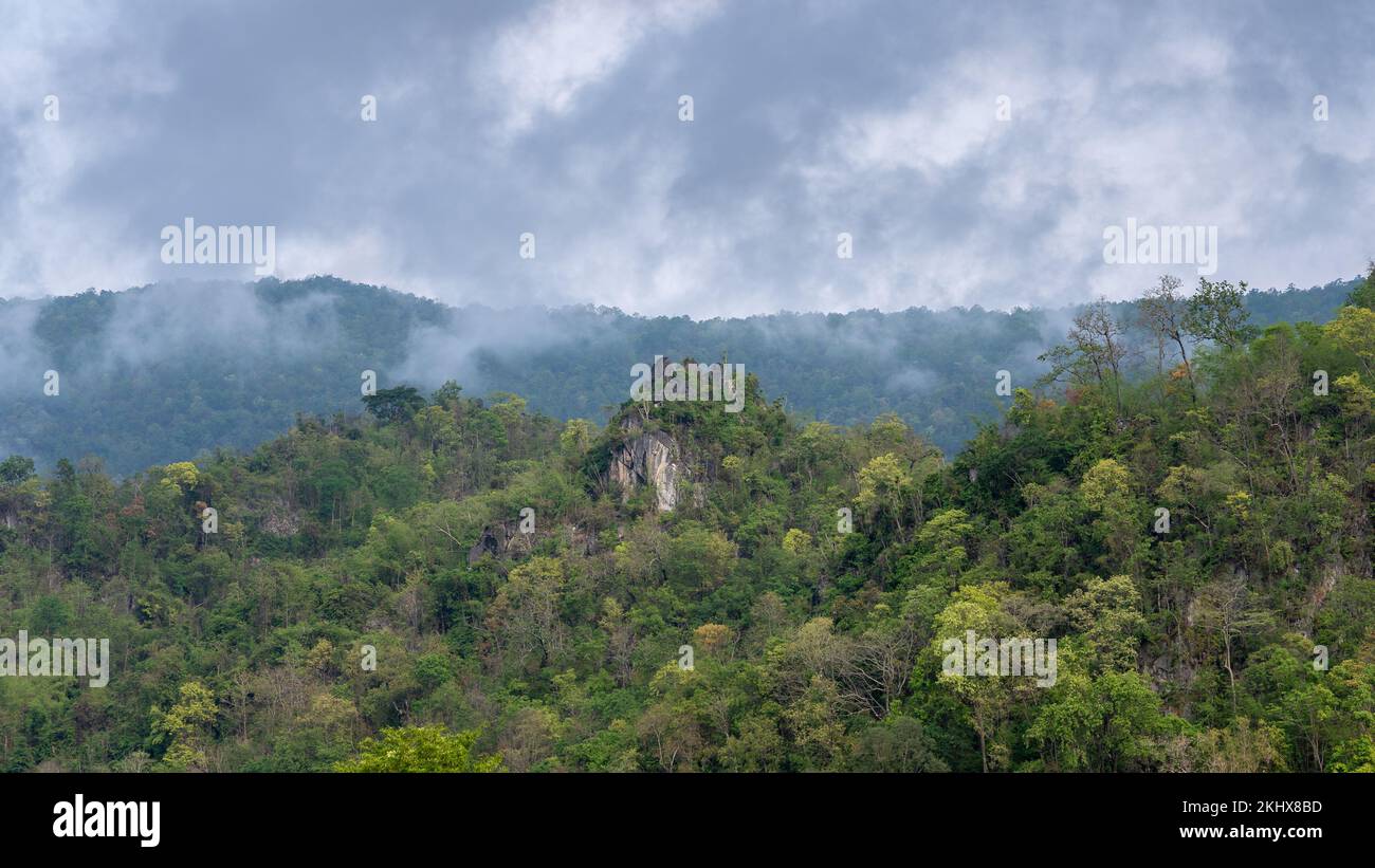 Paisaje rural pintoresco con montaña de piedra caliza y bosque tropical bajo las nubes bajas en el hermoso valle rural, Chiang Dao, Chiang Mai, Tailandia Foto de stock
