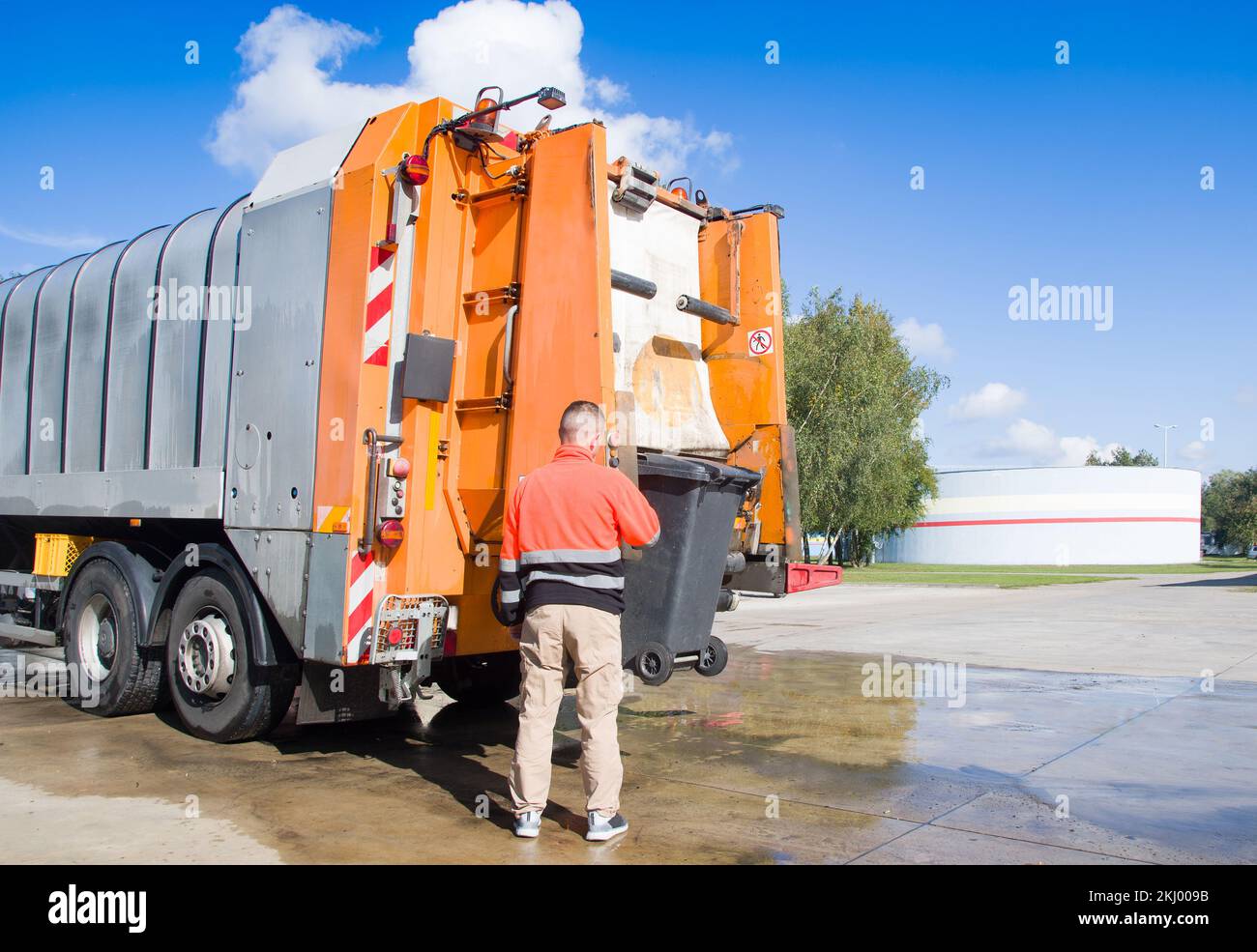 Trabajador de reciclaje urbano municipal camioneta de recogida de basura cargando residuos y basurero Foto de stock