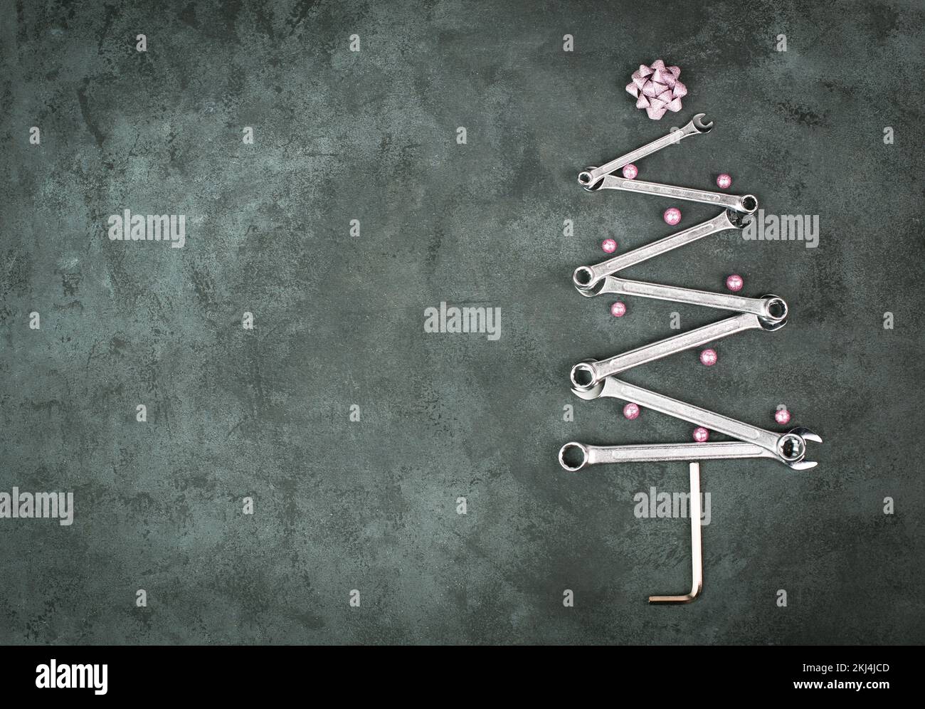 Árbol de Navidad con llaves y bolas, tarjeta de felicitación de año nuevo con herramientas de reparación, fondo oscuro Foto de stock