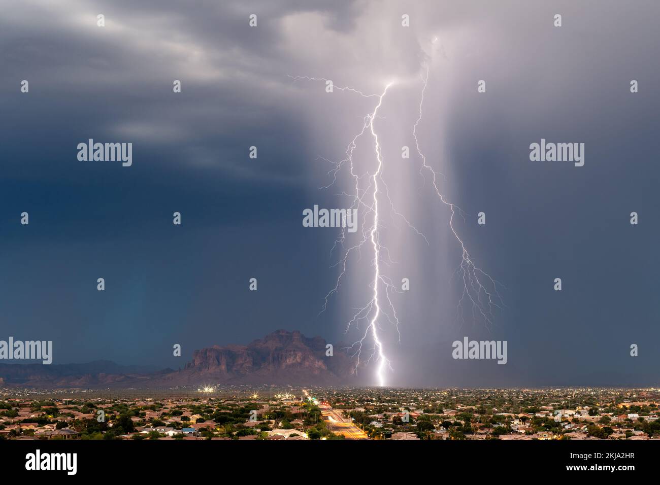 Un poderoso rayo de impacto de una tormenta cerca de las Montañas Superstition en Arizona Foto de stock
