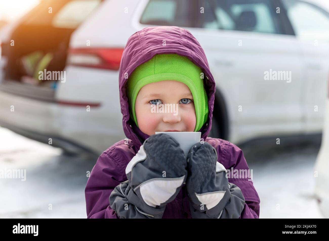 Niña del niño caucásico en ropa de invierno caliente y orejeras