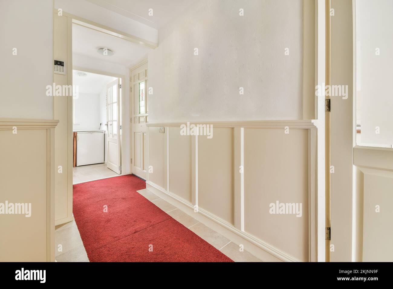 Interior de piso moderno en estilo minimalista con pasillo vacío estrecho iluminado por lámparas Foto de stock