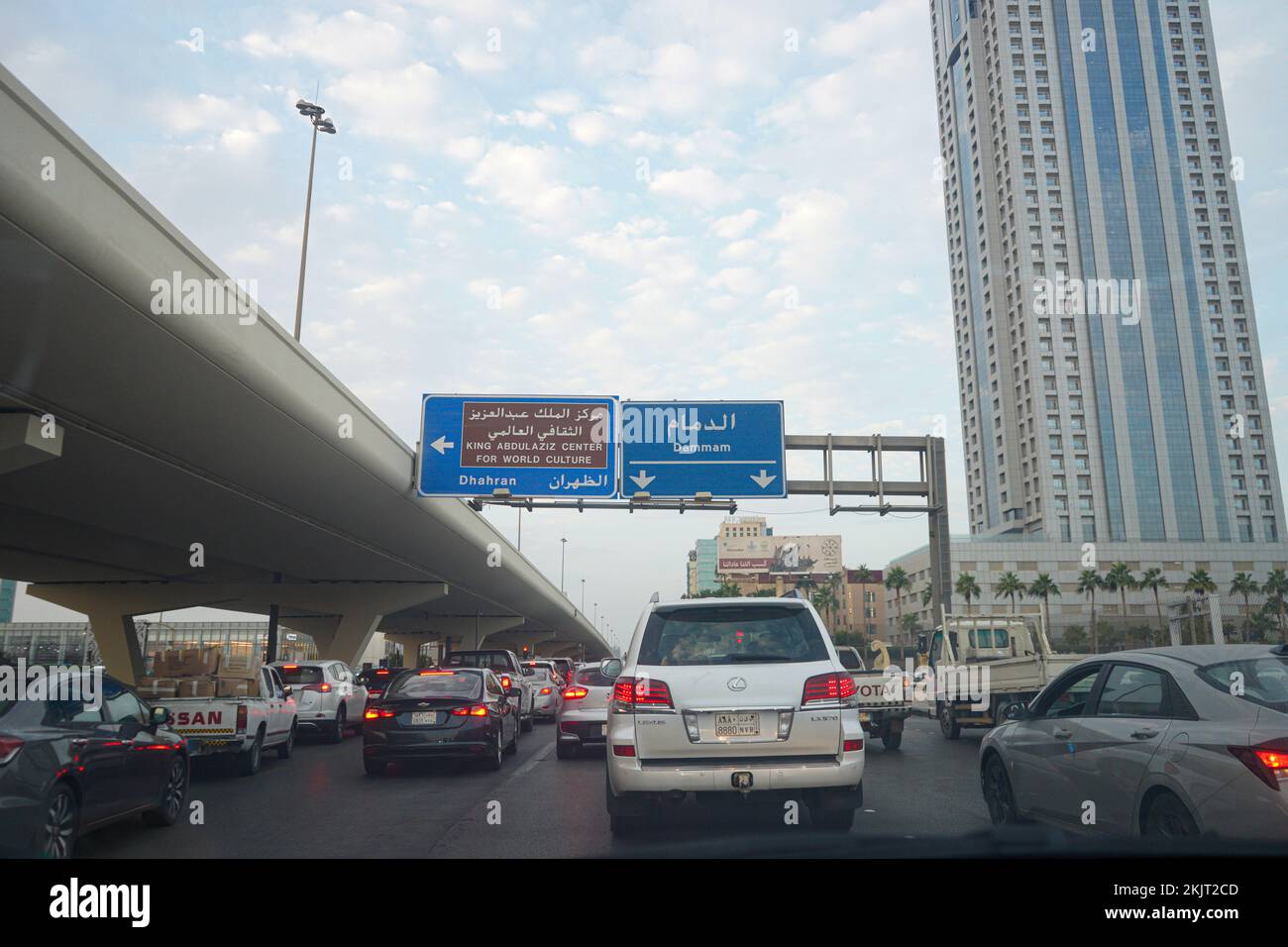 Vista desde el conductor en el semáforo con indicaciones hacia Dammam y Dhahran ciudad y rey Abdulaziz centro mundial de la cultura. Foto de stock
