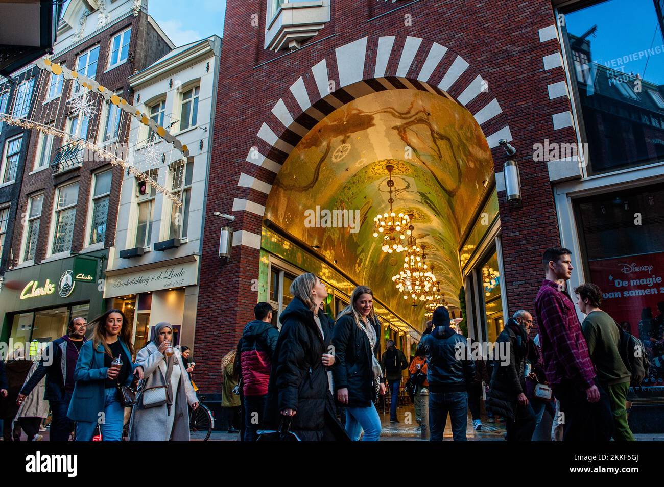 Ámsterdam, Países Bajos. 25th de Nov de 2022. Se ve a la gente pasando  delante de uno de los pasajes llenos de tiendas. En Amsterdam, las tiendas  están listas con ofertas y