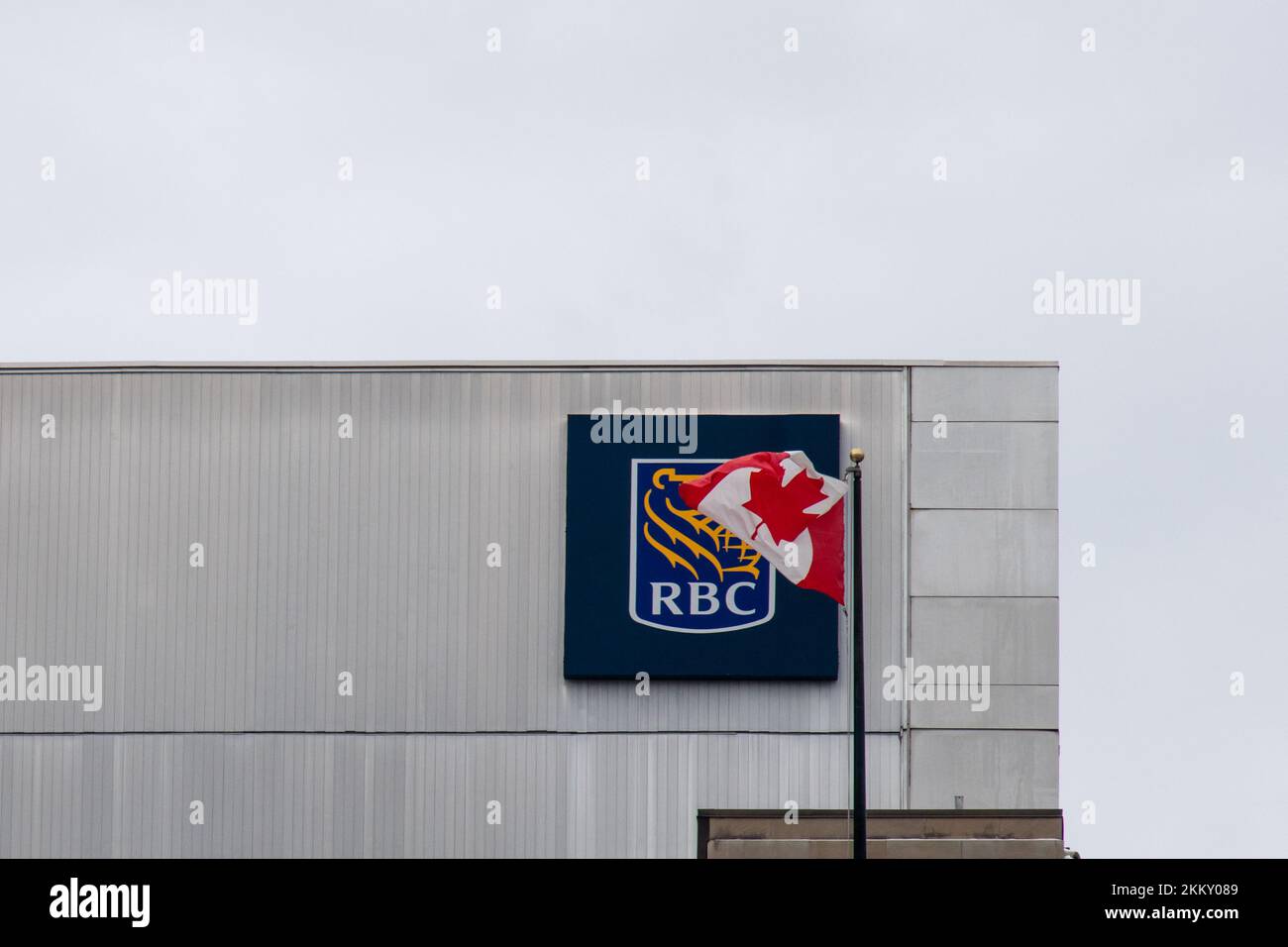 La bandera canadiense ondea frente al logotipo de la RBC, Royal Bank of Canada, en el lado de un edificio de oficinas en Ottawa, la capital de Canadá. Foto de stock