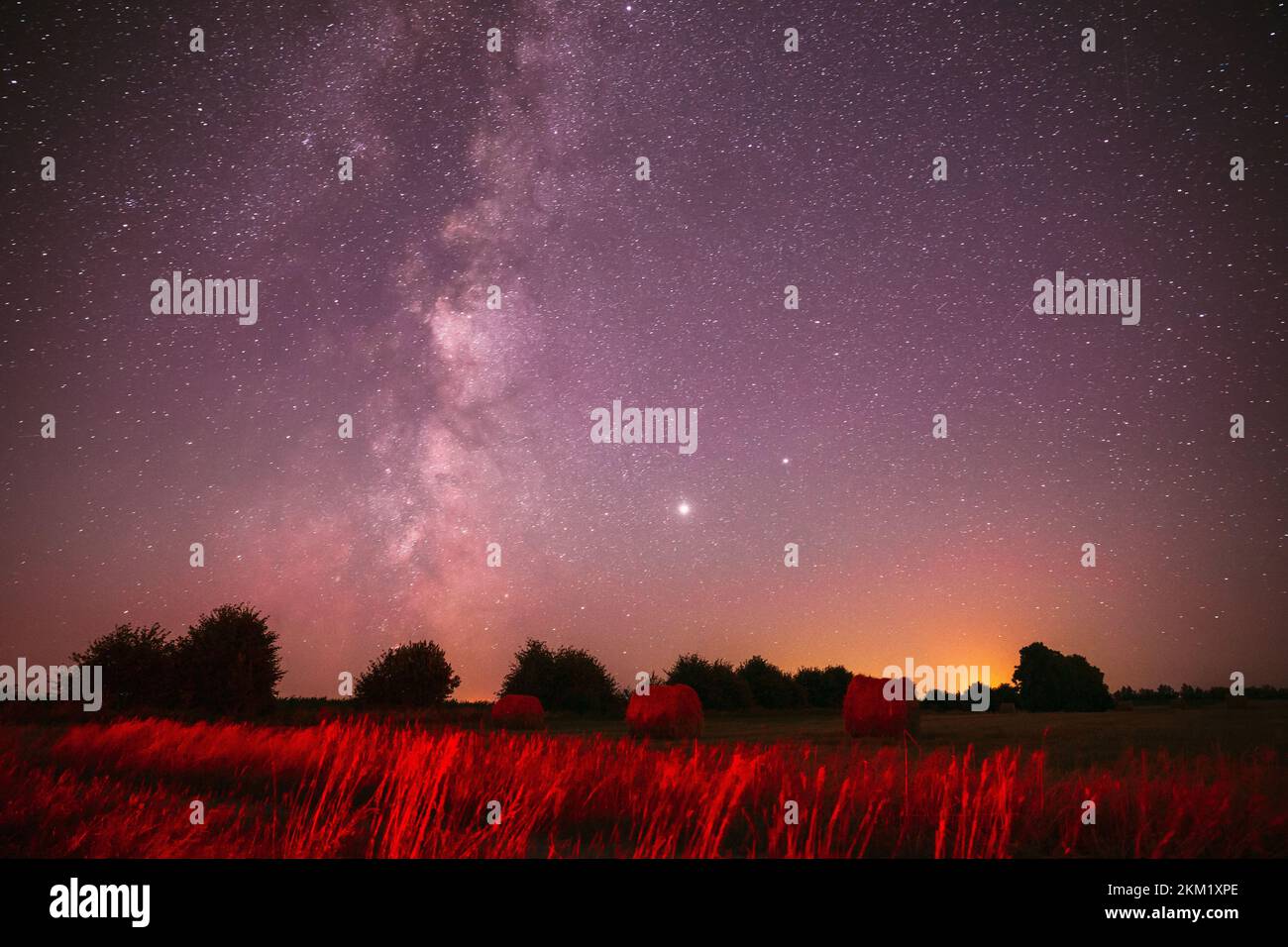 Agrícola Colorful Background Copy Space. Estrellas del cielo natural de la noche real con la vía lechosa sobre el prado del campo con los rodillos de paja en los campos después de la cosecha Foto de stock