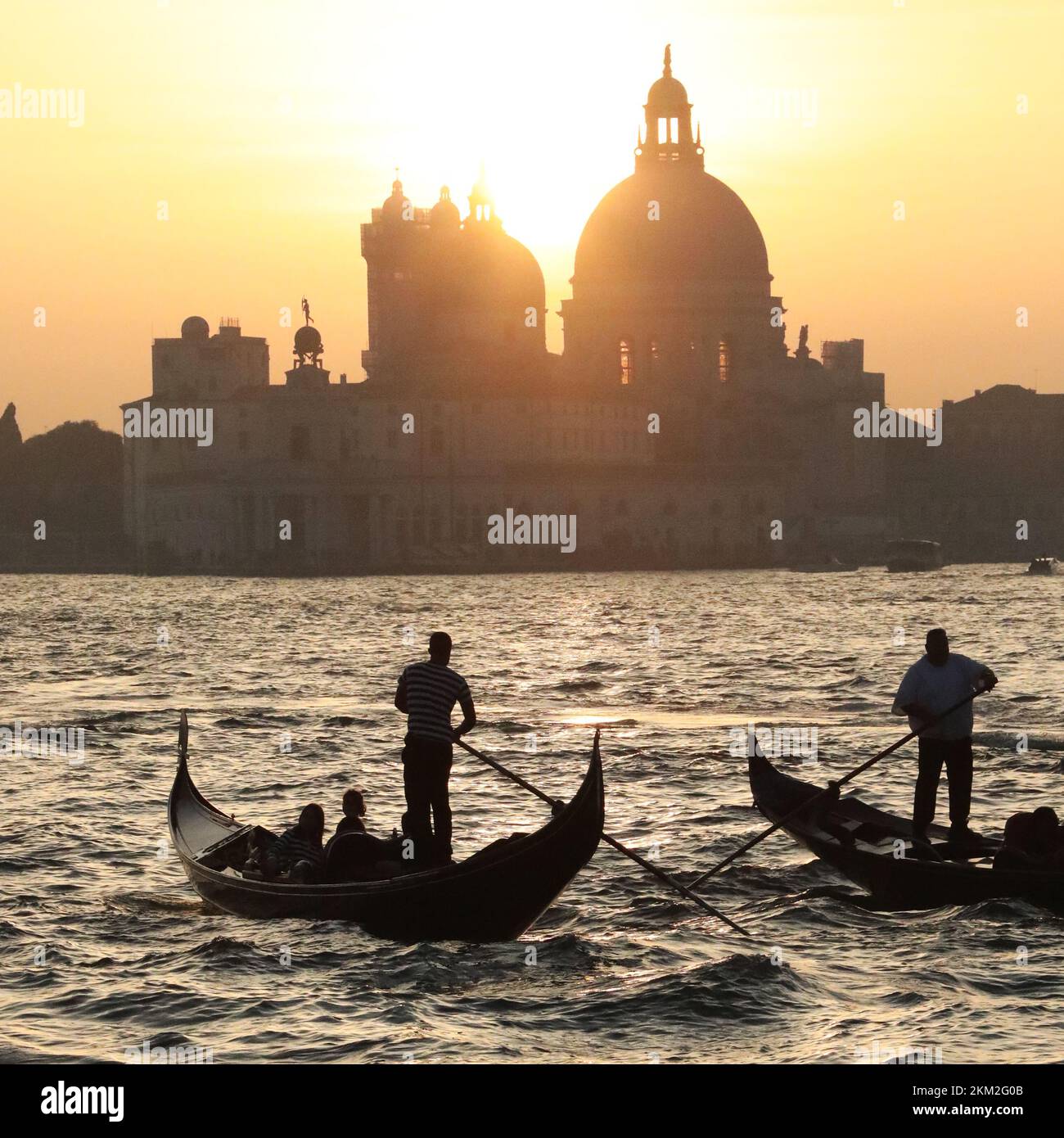 Gondoleros retroiluminados en Venecia, composición cuadrada Foto de stock