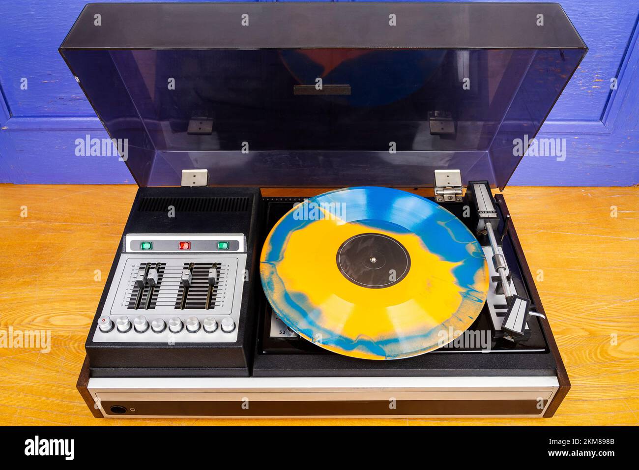 Tocadiscos de vinilo con vinilo azul y naranja sobre una mesa Foto de stock