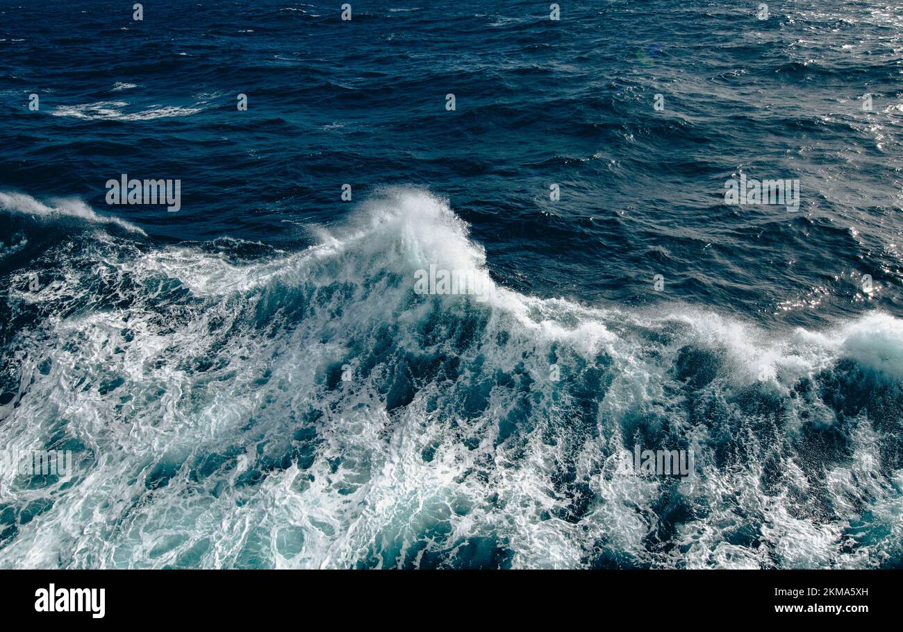 El barco despierta las olas en el Paso Drake, causando que el rocío salga del agua. Foto de stock
