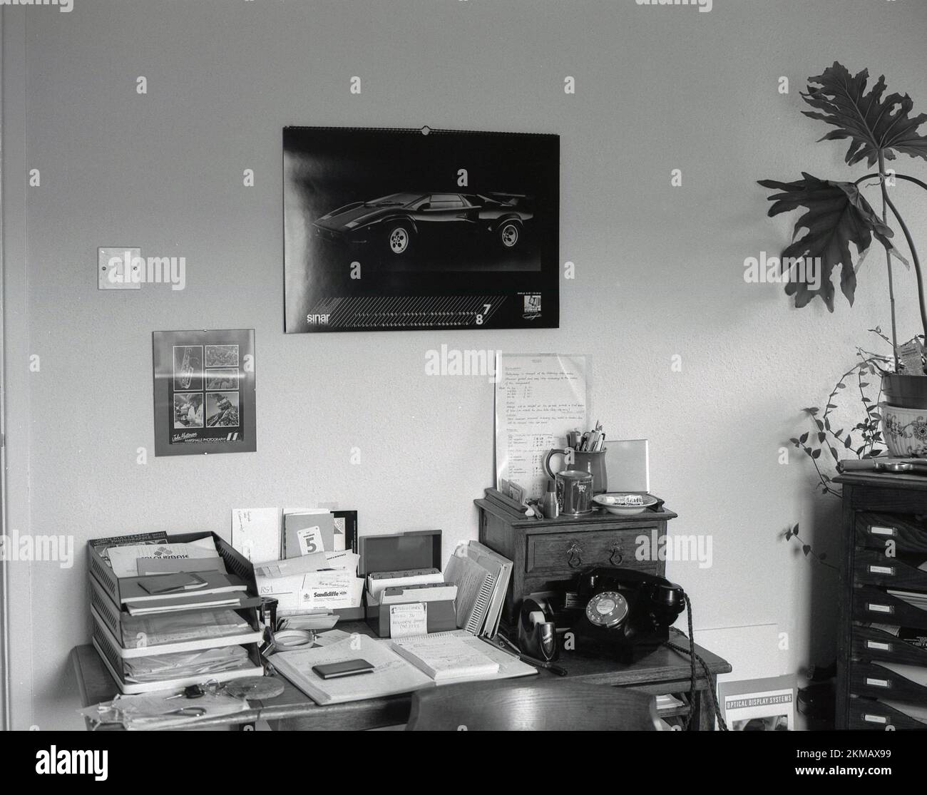 1980s, el escritorio de un fotógrafo en casa, lleno de agenda, índice de tarjetas, teléfono, notas postales, bandeja de entrada con papeleo, Inglaterra, Reino Unido. Foto de stock