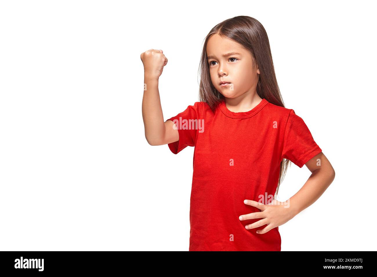 Hermosa niña en camiseta roja sacude su puño Fotografía de stock