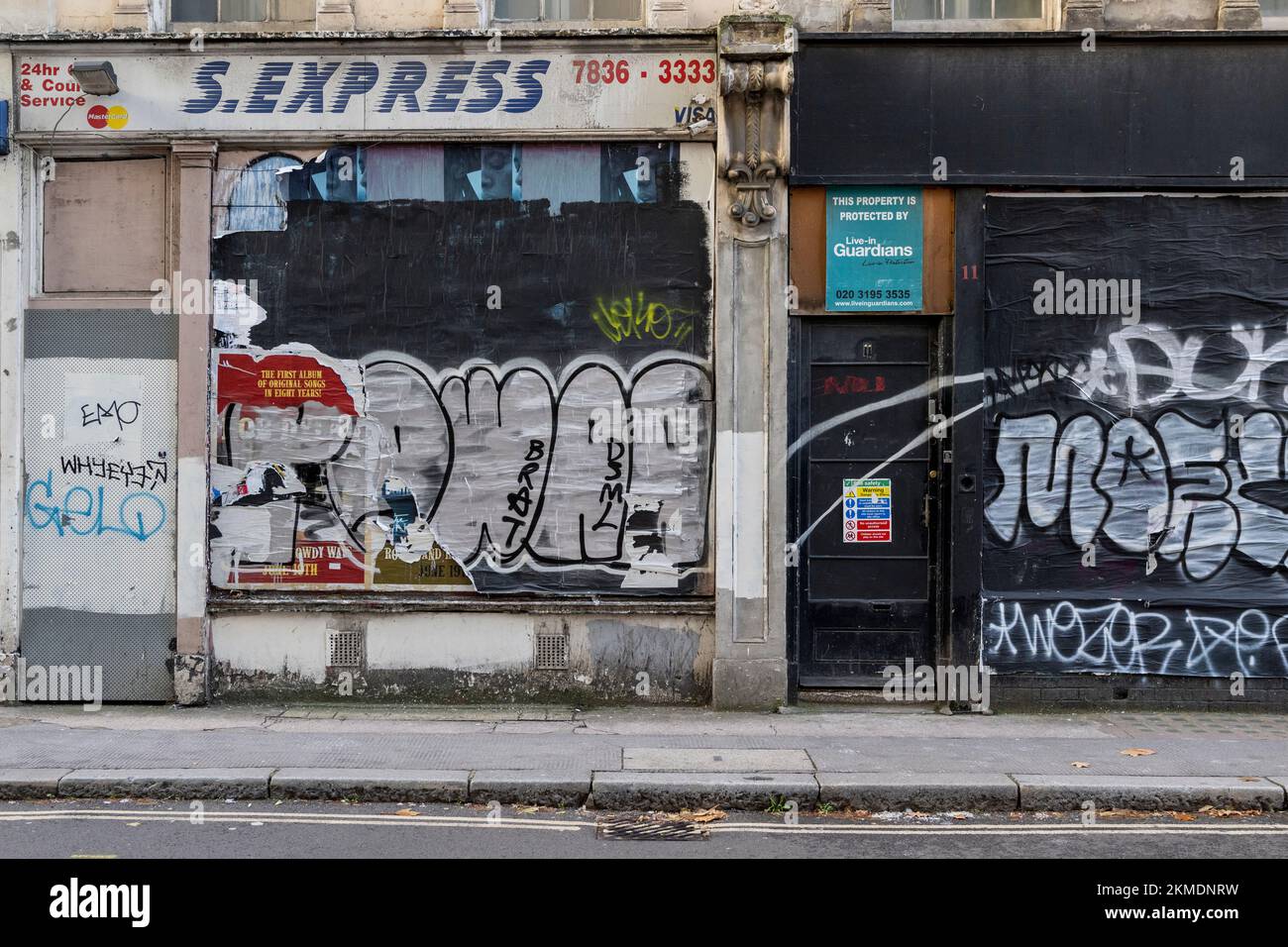 Una tienda cerrada con sus ventanas cubiertas y cubiertas de graffiti