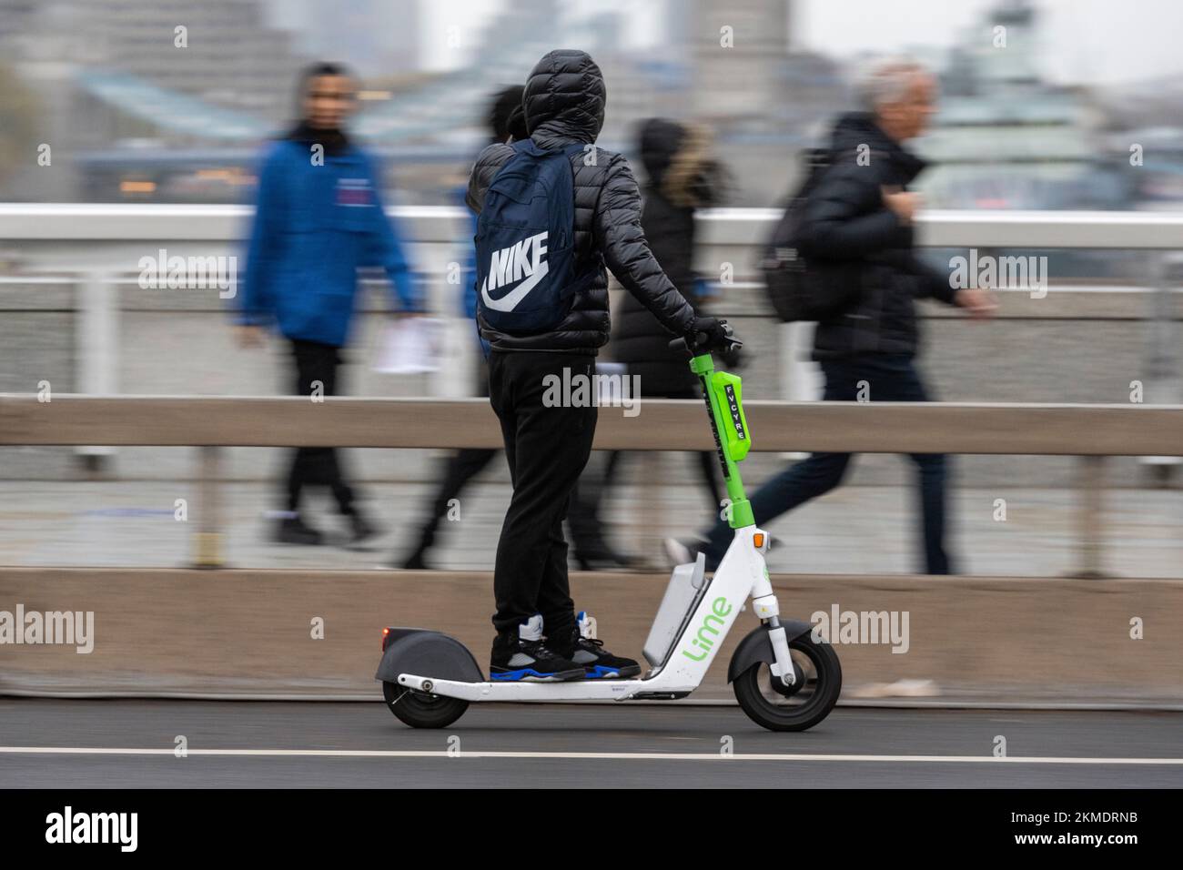 Un hombre que monta en una Lime e e-scooter parte del plan de alquiler de e-scooter Transport for London, London Bridge, Londres, Reino Unido. 16 Nov 2022 Foto de stock