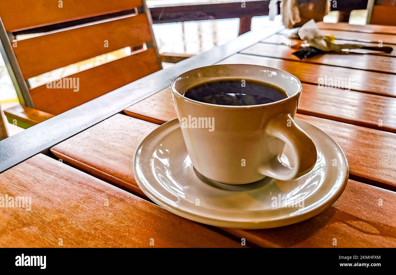 Taza de café americano negro con cuchara y plato sobre comida de mesa y  bebida en el restaurante Zicatela Puerto Escondido Oaxaca México Fotografía  de stock - Alamy